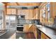 Kitchen with stainless appliances, wooden cabinets, stone countertops, and a window providing natural light and view at 11689 Caribou Dr, Franktown, CO 80116