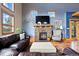 Inviting living room featuring a stone fireplace, large windows, and comfortable seating, creating a warm atmosphere at 11689 Caribou Dr, Franktown, CO 80116