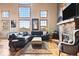 Bright living room featuring a stone fireplace, ample natural light, and hardwood floors at 11689 Caribou Dr, Franktown, CO 80116