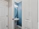 This bathroom features a pedestal sink, modern lighting fixtures, and is painted a lovely blue at 19917 Mitchell Cir, Denver, CO 80249