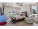 A comfortable bedroom includes a sitting chair, ceiling fan, and dual windows at 19917 Mitchell Cir, Denver, CO 80249