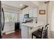 Bright kitchen featuring white cabinetry, tiled countertops, modern appliances, and a convenient breakfast bar at 19917 Mitchell Cir, Denver, CO 80249