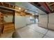 Unfinished basement with concrete floor and walls, wooden stairs, and a small window at 2100 Bibles Hill Dr, Franktown, CO 80116
