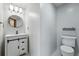 Updated half bathroom features a modern vanity with white cabinets, black hardware, and an oval mirror at 2100 Bibles Hill Dr, Franktown, CO 80116