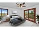 Comfortable bedroom with a ceiling fan, neutral decor, balcony access, and plenty of natural light at 2100 Bibles Hill Dr, Franktown, CO 80116