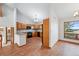 Spacious eat-in kitchen with warm wood cabinets, granite countertops, and access to a view filled dining space at 2100 Bibles Hill Dr, Franktown, CO 80116