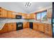 Traditional kitchen with wooden cabinets, granite countertops, black appliances, and a window over the sink at 2100 Bibles Hill Dr, Franktown, CO 80116