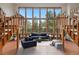 Living room with floor to ceiling windows, a staircase, and blue furniture at 2100 Bibles Hill Dr, Franktown, CO 80116
