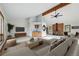 Staged living room featuring neutral walls, wood beams, a fireplace, and a wet bar area at 2100 Bibles Hill Dr, Franktown, CO 80116