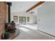 Living room featuring a brick fireplace, wood beams, a ceiling fan and sliding glass doors at 2100 Bibles Hill Dr, Franktown, CO 80116