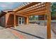 Spacious brick patio with a wooden pergola and outdoor access to a building at 2100 Bibles Hill Dr, Franktown, CO 80116