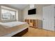 Well-lit bedroom features wood floors and a mounted flatscreen television at 843 Snowberry St, Longmont, CO 80503