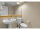 Neutral half bathroom featuring a pedestal sink, toilet, and neutral decor at 843 Snowberry St, Longmont, CO 80503