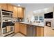 Well-equipped kitchen with modern appliances, light wood cabinets, and an open view to the living room, perfect for entertaining at 843 Snowberry St, Longmont, CO 80503