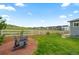 Relaxing backyard featuring a white fence, grassy lawn, and comfortable Adirondack chairs at 5290 Silver Hare Ct, Castle Rock, CO 80104