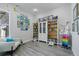 Bright bedroom with grey wood flooring, large bookcase, white chair, and custom art at 5290 Silver Hare Ct, Castle Rock, CO 80104