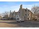 View of tan condo building from the parking lot, with multiple parked cars and bare trees at 4068 S Atchison Way # 301, Aurora, CO 80014