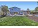 Spacious backyard with a well-manicured lawn, wooden deck, and garden beds; perfect for outdoor enjoyment at 7380 Tabor St, Arvada, CO 80005