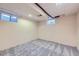 Finished basement with neutral carpet, windows and drop ceiling, offering potential for a recreation or storage space at 7380 Tabor St, Arvada, CO 80005