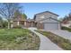 Charming two-story home boasts a well-manicured front yard and inviting walkway at 7380 Tabor St, Arvada, CO 80005