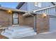 Welcoming front entrance featuring a brick facade and covered porch at 7380 Tabor St, Arvada, CO 80005