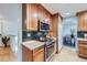 Modern kitchen boasts wood cabinetry, stainless steel appliances, and tiled backsplash at 7380 Tabor St, Arvada, CO 80005