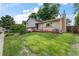 This is a beautiful home with a well-manicured lawn, quaint front porch with chairs, and a classic brick facade at 1161 S Johnson Way, Lakewood, CO 80232