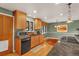 Updated kitchen with wood cabinets, black appliances, and hardwood flooring at 1161 S Johnson Way, Lakewood, CO 80232