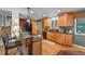 Well-lit kitchen features wood floors, wood cabinets, granite countertops, and black appliances at 1161 S Johnson Way, Lakewood, CO 80232