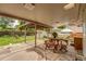 Covered back patio with a table, chairs, and view of the large backyard at 1161 S Johnson Way, Lakewood, CO 80232