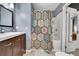 Bathroom with stylish wood vanity and a shower-tub combination featuring a colorful patterned shower curtain at 1711 Cato Cir # 21, Lafayette, CO 80026