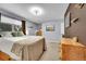 This is a bedroom with a large bed, carpeted floors and a brown accent wall with two wooden dressers at 1711 Cato Cir # 21, Lafayette, CO 80026