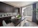 Dining room with sleek cabinetry, a table with white chairs, and a large window that brings in lots of natural light at 21925 E 51St St, Aurora, CO 80019