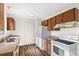 Kitchen with wood cabinets, white appliances, and laminate countertops at 3124 W 9Th Avenue Pl, Broomfield, CO 80020