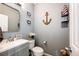 Clean bathroom with gray vanity, white toilet and nautical-themed decor at 17725 E 99Th Ave, Commerce City, CO 80022