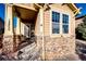 Inviting front porch with stonework and a charming bench at 17725 E 99Th Ave, Commerce City, CO 80022