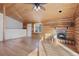 Living room with wood walls, wood floors, and a stone fireplace at 721 Aspen Way, Evergreen, CO 80439