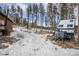 Snowy yard with a shed and camper in a wooded area at 721 Aspen Way, Evergreen, CO 80439