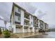 Modern apartment building with garage parking below and private balconies on each floor at 6153 N Ceylon St # 2-202, Denver, CO 80249