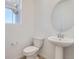 Elegant half bathroom with a pedestal sink, stylish mirror, and modern fixtures in a well-lit space at 11008 Snowdon St, Parker, CO 80134