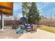 Outdoor patio area with stylish wicker furniture set against a backdrop of mature trees and a blue outbuilding at 330 W Fair Ave, Littleton, CO 80120