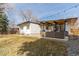 A spacious backyard showcasing lush grass, mature trees, and a covered patio for outdoor entertaining and relaxation at 330 W Fair Ave, Littleton, CO 80120