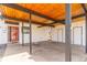 Carport with a striking wood ceiling, red door entrance, and convenient storage access at 330 W Fair Ave, Littleton, CO 80120