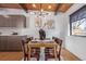 Dining area featuring modern light fixture, wood table, and cabinet storage, with view of backyard at 330 W Fair Ave, Littleton, CO 80120