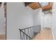 Hallway with light hardwood floors, a black metal banister, and wood ceiling detail at 330 W Fair Ave, Littleton, CO 80120