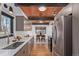 Spacious kitchen with stainless steel appliances, quartz countertop, and wood ceiling at 330 W Fair Ave, Littleton, CO 80120