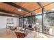 Sun-filled living room featuring wood ceilings, hardwood floors, and expansive windows overlooking lush greenery at 330 W Fair Ave, Littleton, CO 80120