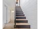 Staircase featuring black risers and wooden treads leading to an upstairs hallway at 330 W Fair Ave, Littleton, CO 80120