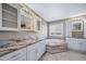 Elegant bathroom featuring marble counters, dual sinks, tub and white cabinetry at 7720 S Queensburg Way, Aurora, CO 80016