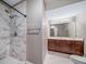Elegant bathroom featuring a marble tiled shower, modern fixtures, and a wood vanity at 7720 S Queensburg Way, Aurora, CO 80016